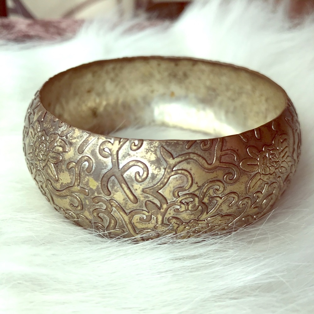 Metal bangle with floral/vine.